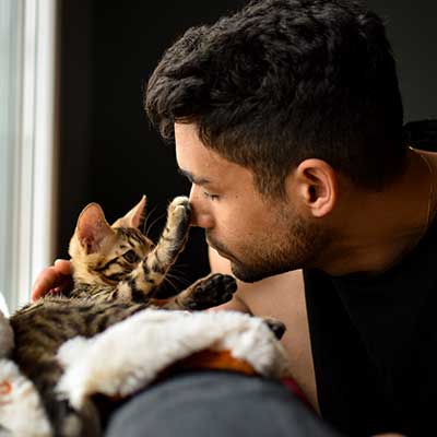 A man snuggling his cat